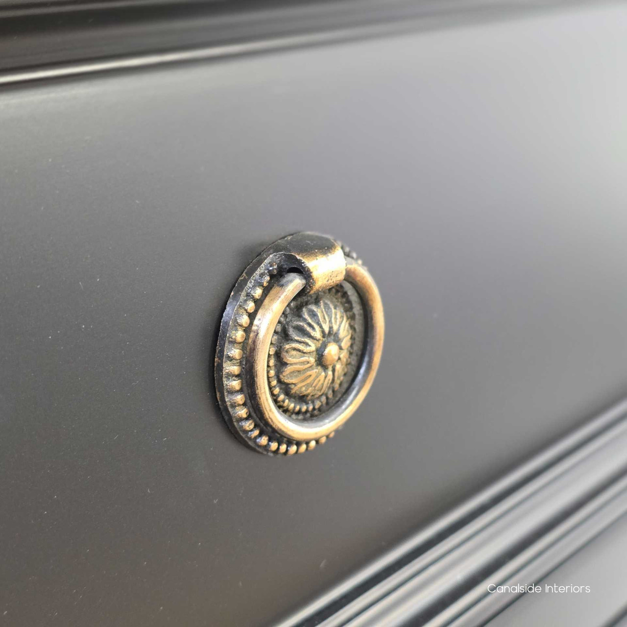 Detailed shot of the brass ring pull hardware on the Peninsula black drawer chest.