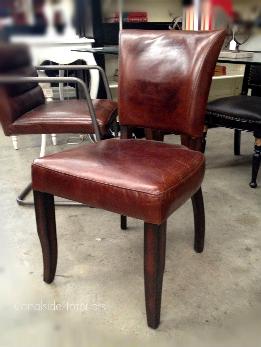 Rich brown leather upholstery paired with elegant weathered oak legs makes this dining chair a classic piece for any Canalside Interiors' collection