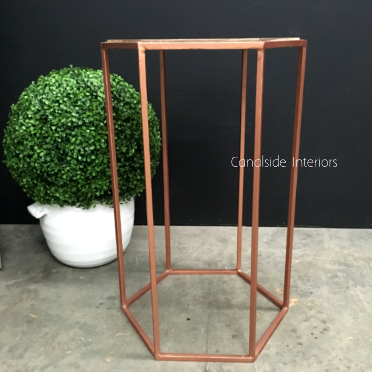 View of the Polygon Bar Stool in distressed copper, showcasing its sleek design and industrial charm.