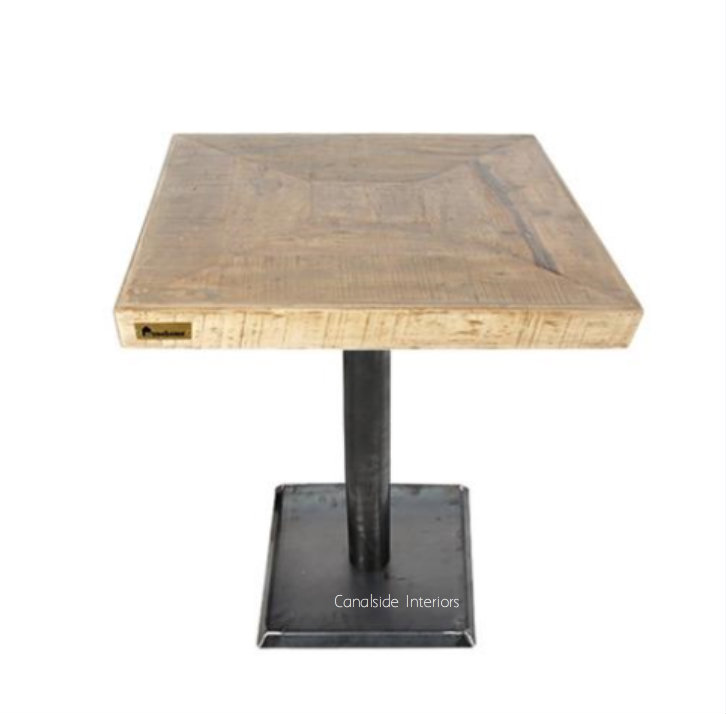 Angled shot of the table, focusing on the sturdy base that combines industrial strength with rustic aesthetics.