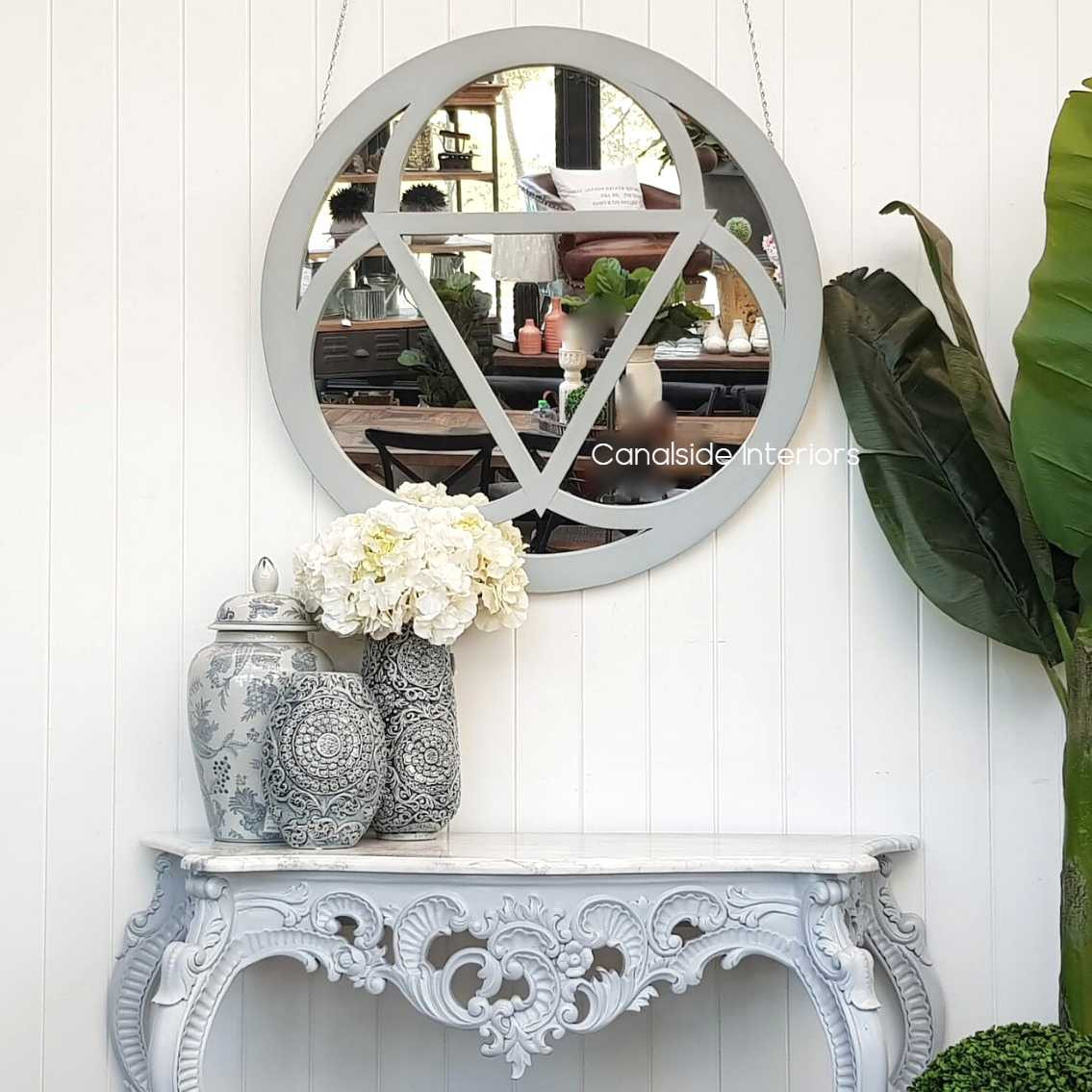 Ambient image showing the mirror as a focal point above an intricately carved marble console, adding depth and elegance.