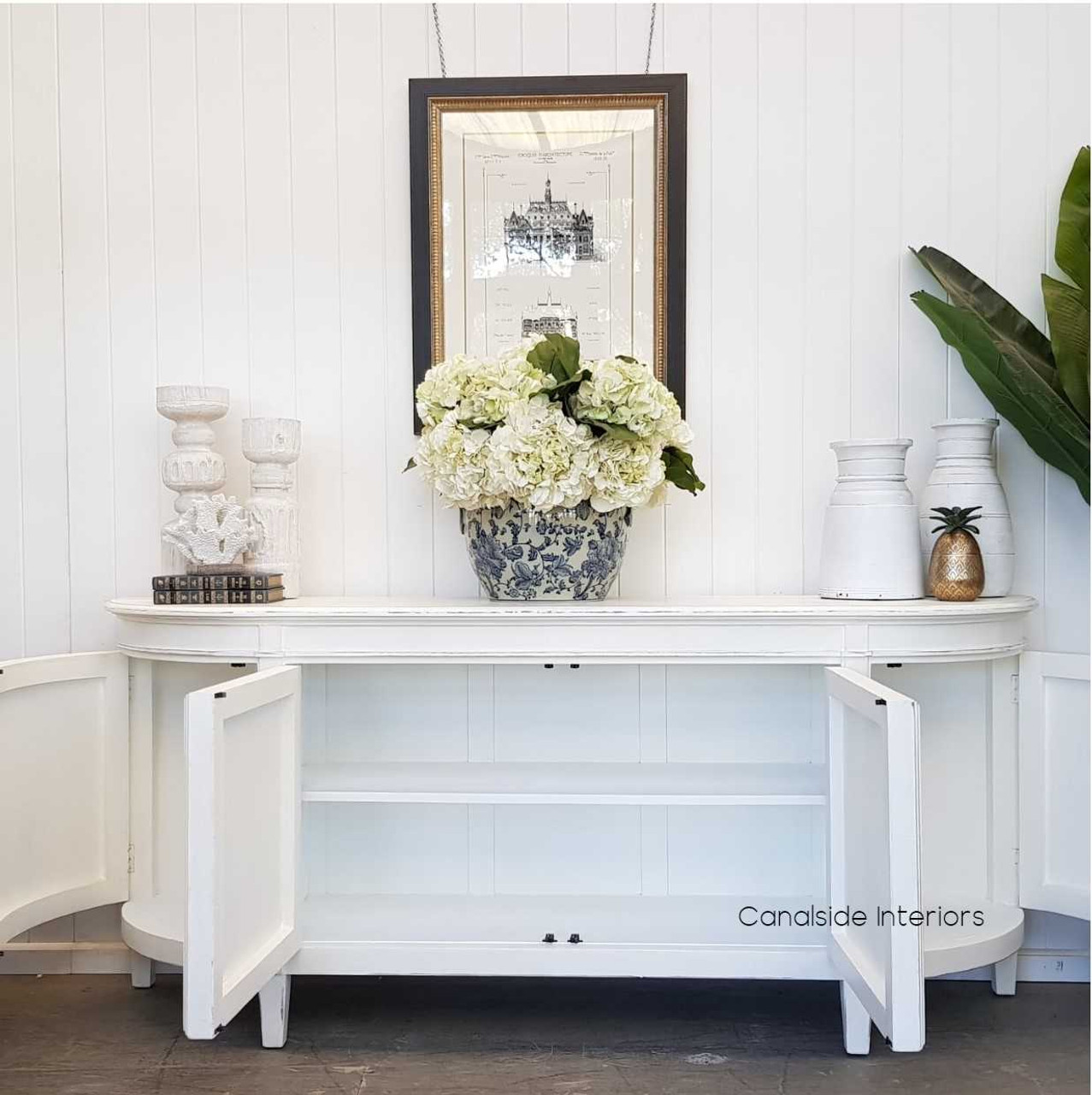Transform your living room with the Francia Sideboard's distressed off white elegance, a versatile piece that embodies the craftsmanship of Canalside Interiors.