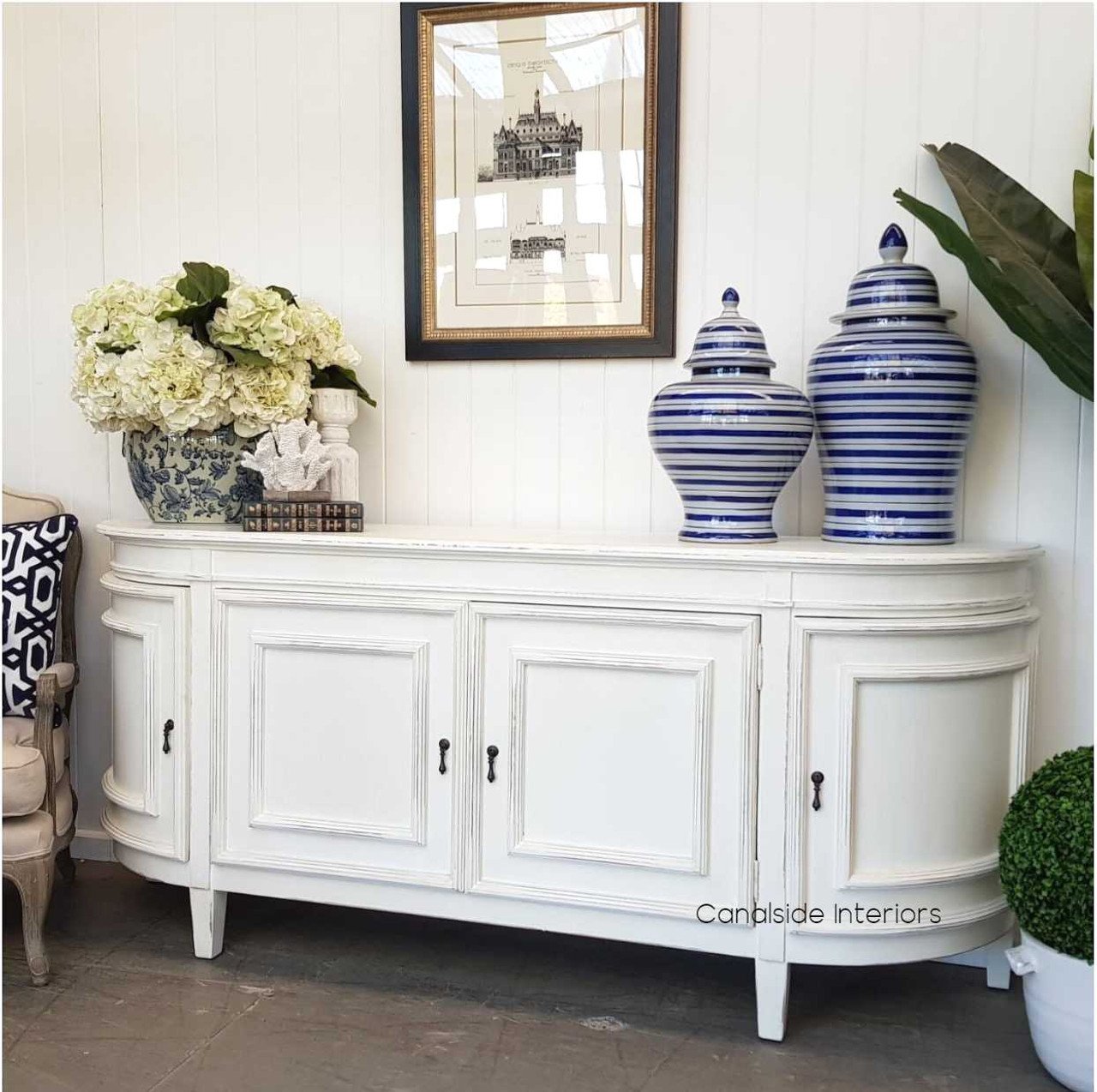 The Francia Sideboard’s graceful curves and distressed off white finish offer a serene, stylish solution for lounge room storage, reflecting the quality of Canalside Interiors.