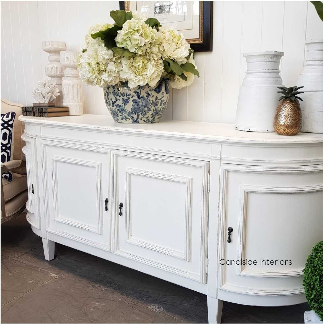 The Francia Sideboard in distressed off white enhances the classic charm of your bedroom decor, offering a modern twist on traditional storage solutions.