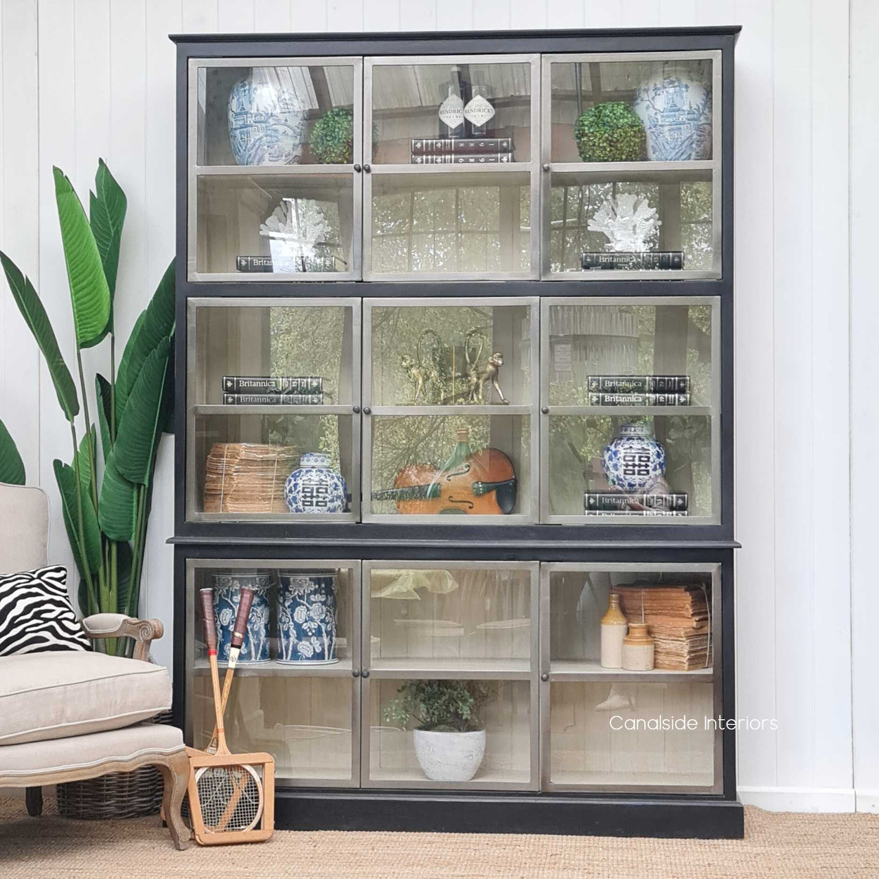 Front view of the Bellport 3 Door Display Unit II at Canalside Interiors, highlighting its distressed charcoal finish and elegant metal doors.