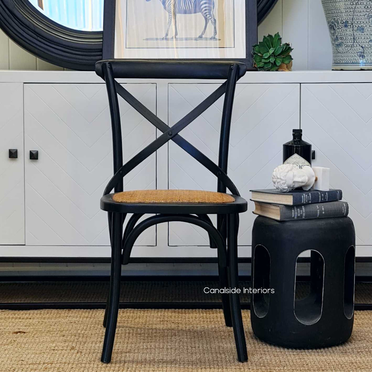 The side profile of the Distressed Black Cross Back Chair showcases its sturdy legs and comfortable seat height, ideal for extended seating in a home office.