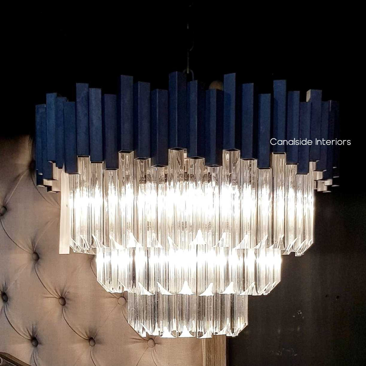 Canalside Interiors' Odeon Chandelier in Medium reflects a stunning array of light, ideal for bringing a timeless sparkle to a modern bedroom.