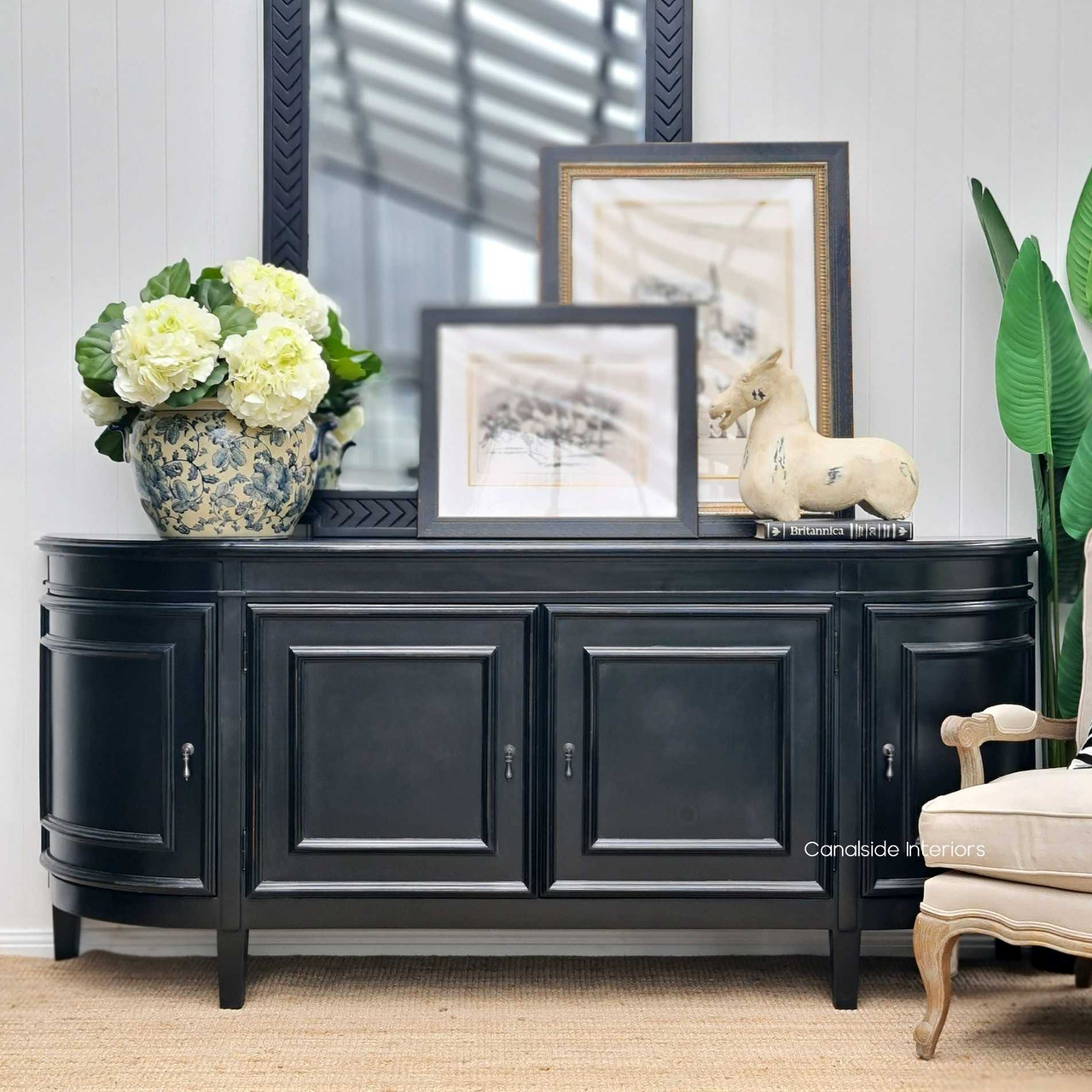 The Francia Curved Sideboard in distressed black charcoal from Canalside Interiors, with a classical silhouette perfect for enhancing the timeless elegance of a Hamptons-style bedroom