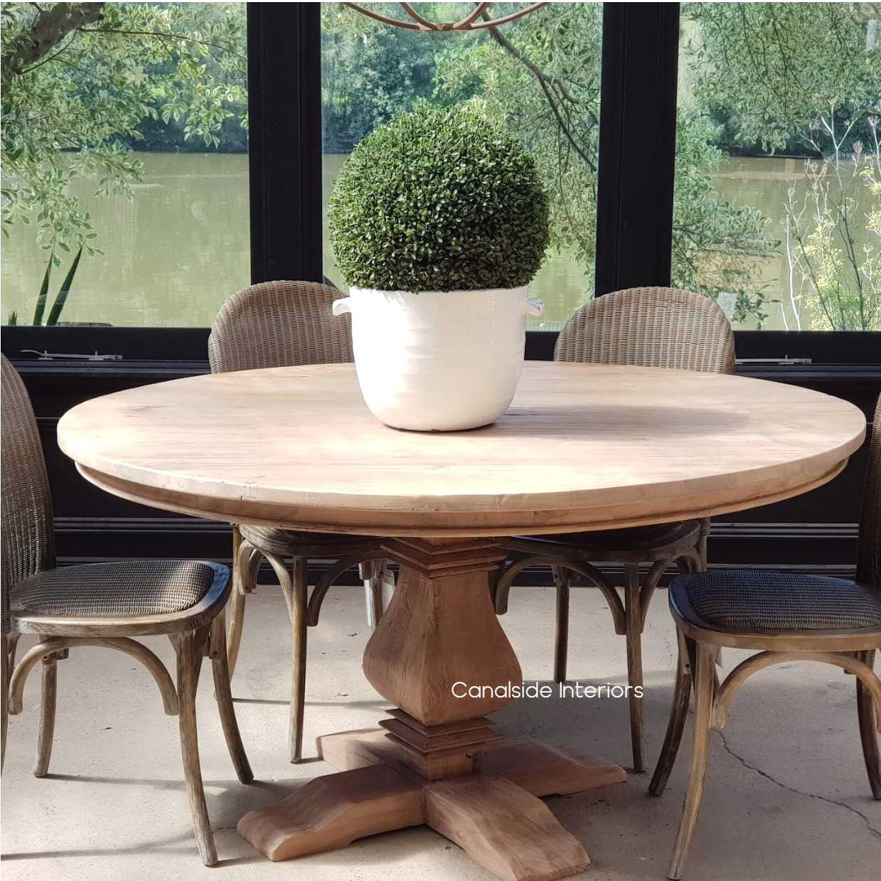 Front view of the Artisan Round Dining Table at Canalside Interiors, displaying its recycled timber craftsmanship and hand-carved pedestal base.