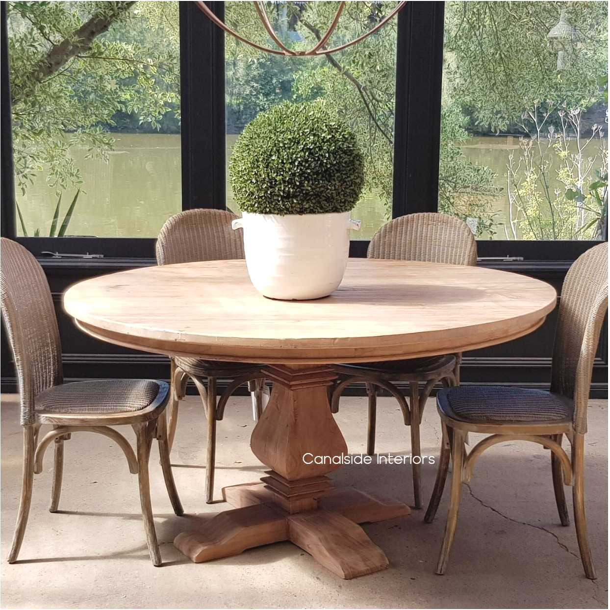 Front view of the Artisan Round Dining Table at Canalside Interiors, displaying its recycled timber craftsmanship and hand-carved pedestal base.