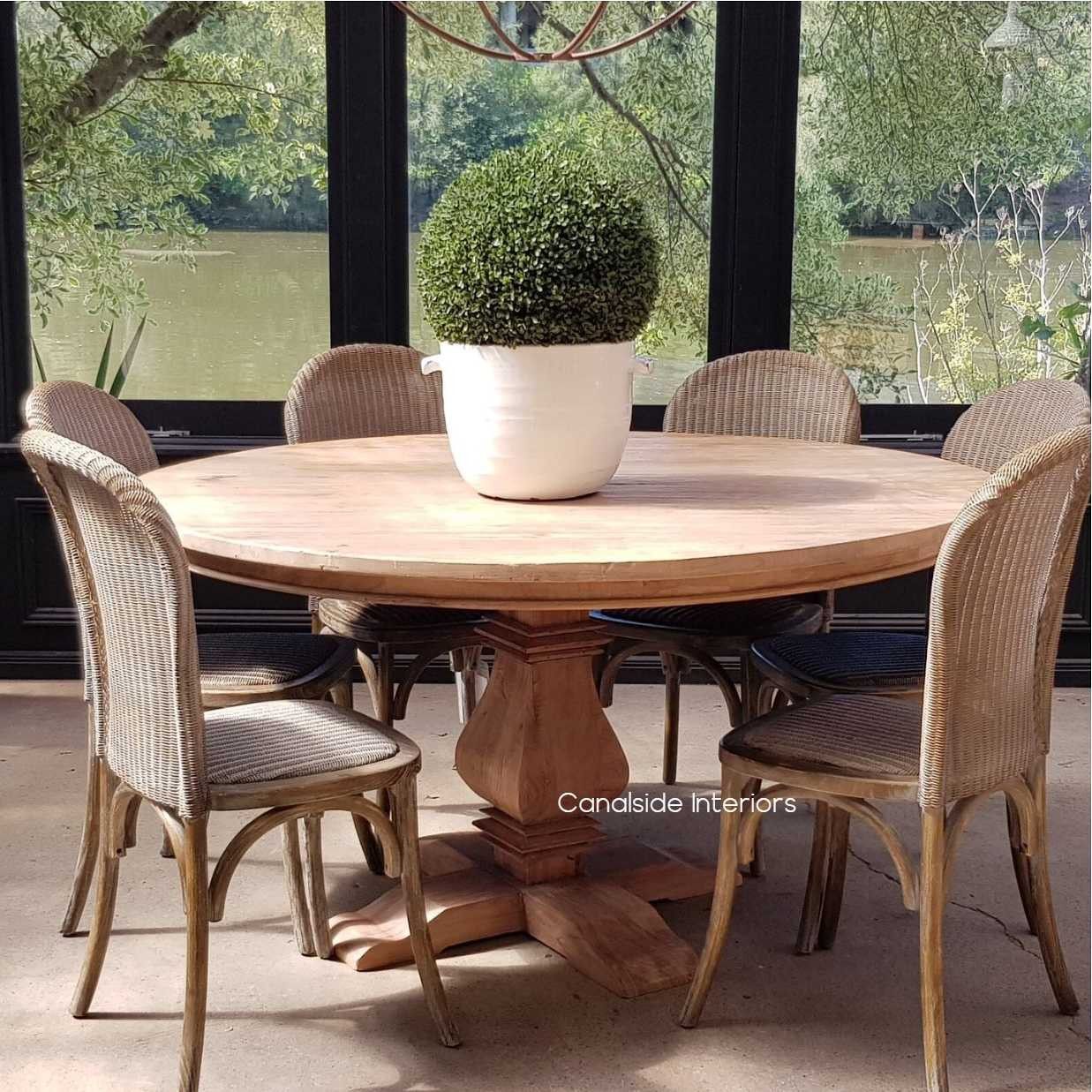 Front view of the Artisan Round Dining Table at Canalside Interiors, displaying its recycled timber craftsmanship and hand-carved pedestal base.