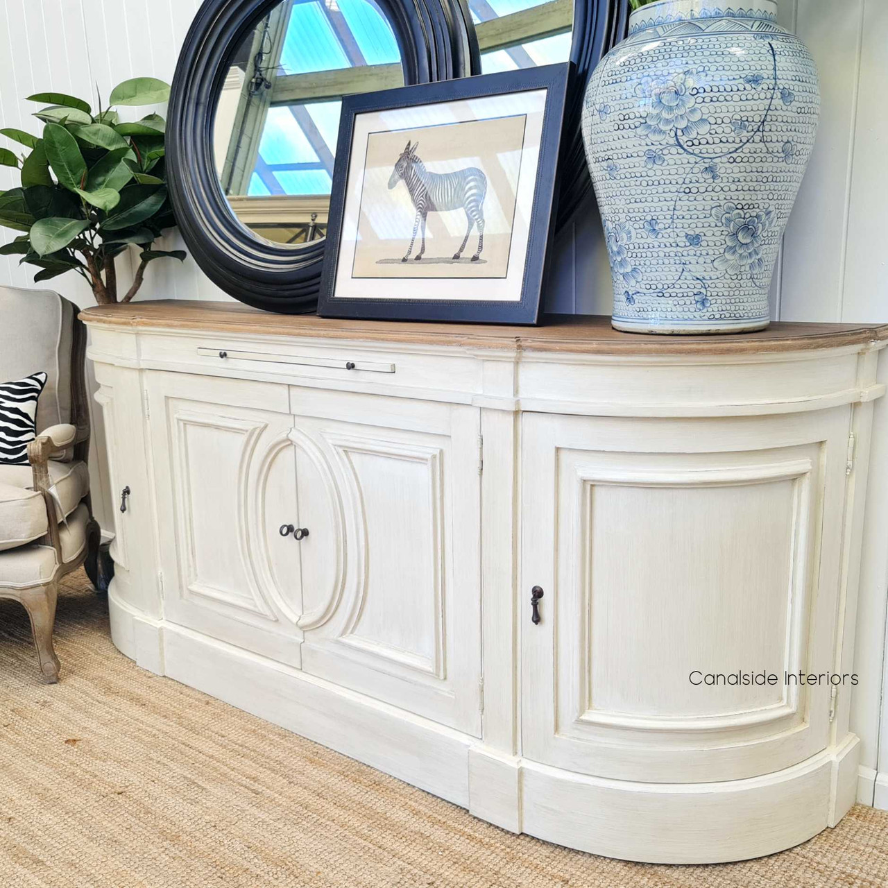 Complementing a stylish mirror, the Bastian Sideboard enhances the reflective beauty of the space, creating a harmonious balance between functionality and aesthetic