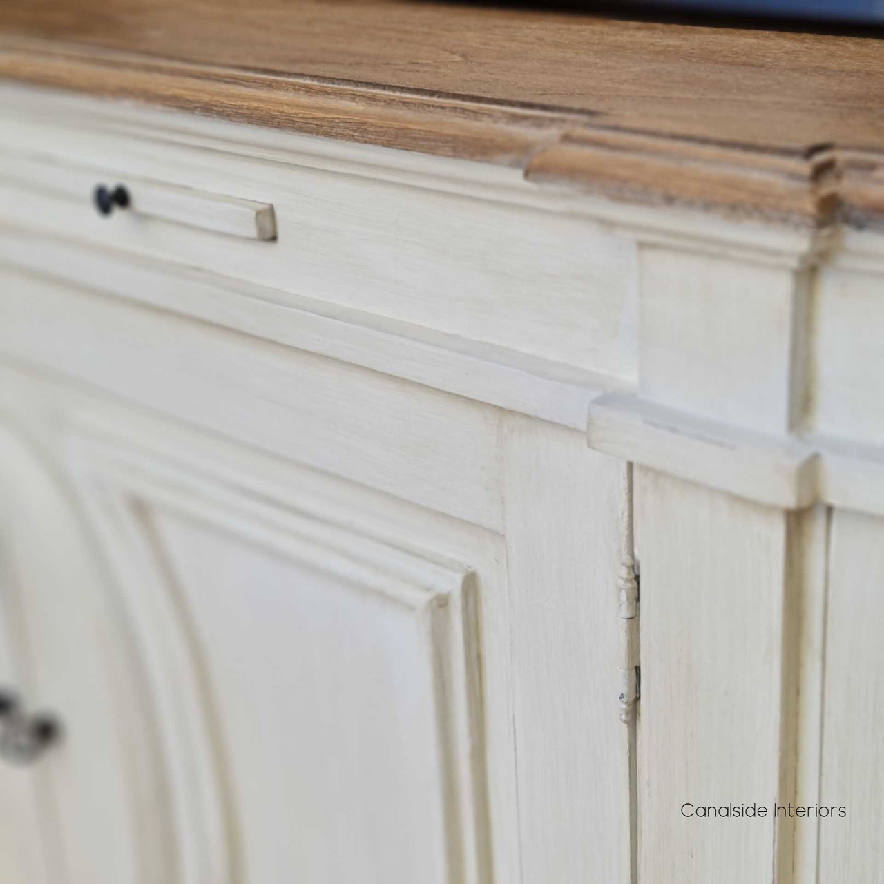 The beautifully distressed surface of the Bastian Large Sideboard adds a layer of rustic charm to a classical bedroom ensemble, blending storage with style.