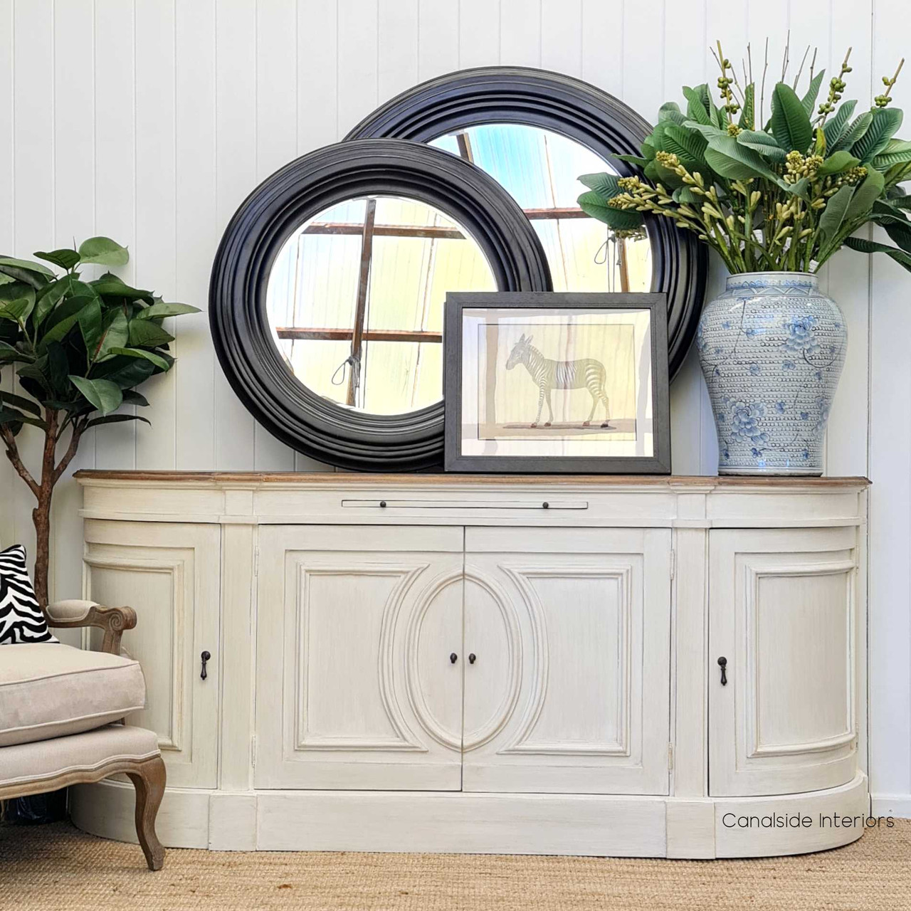 This front view of the Bastian Large Sideboard, featuring a distressed stone finish and weathered oak top, epitomizes timeless elegance suitable for any coastal-inspired interior