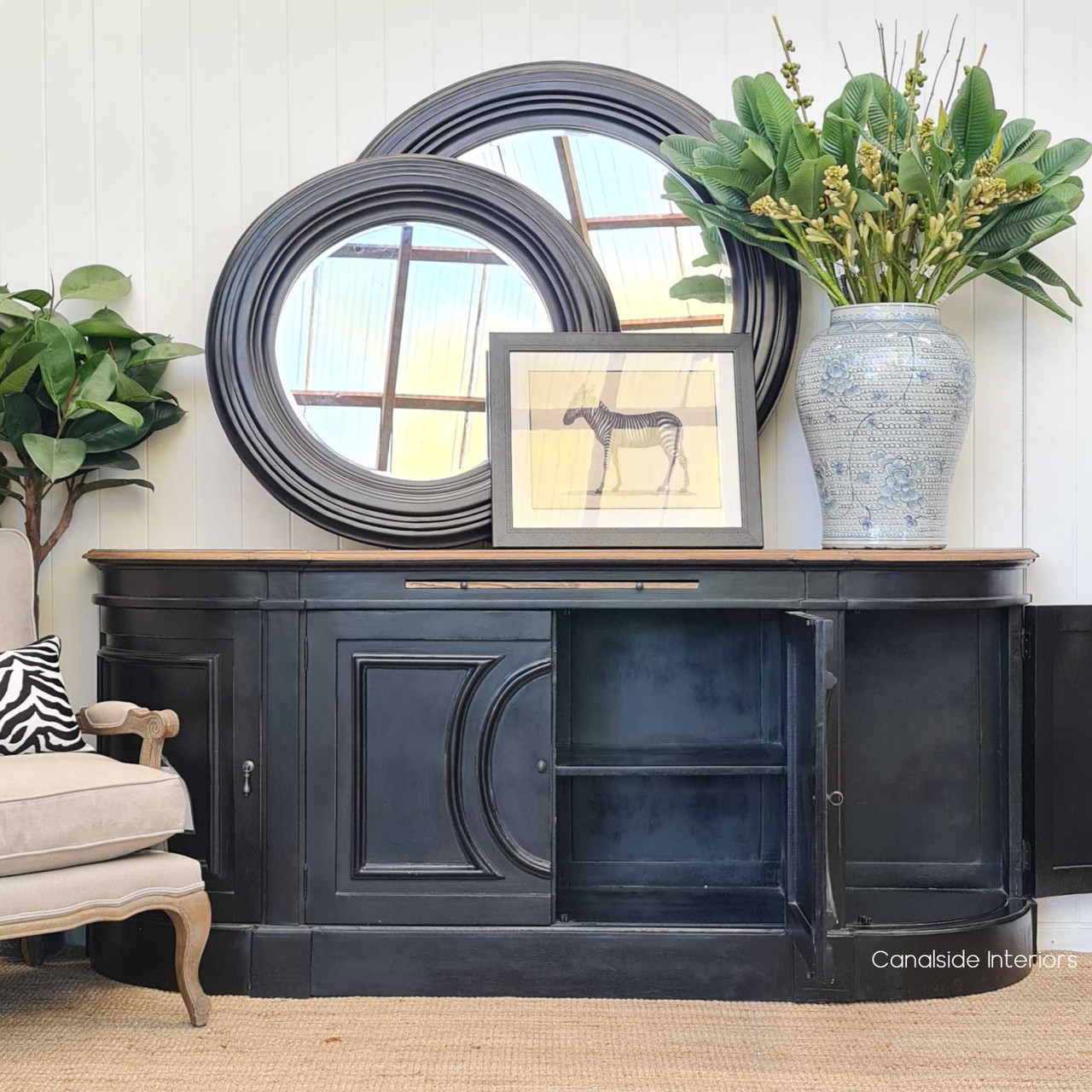 The Bastian Large Sideboard's doors slightly ajar, revealing ample storage space within, perfect for a timeless and organized dining area