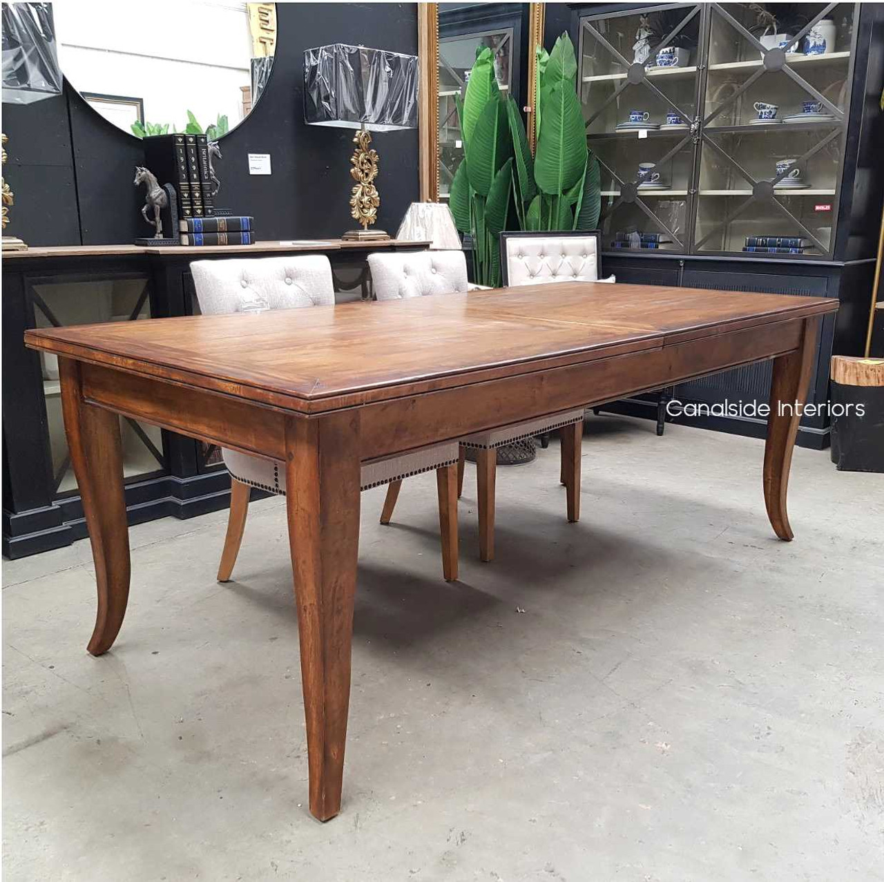Showcasing the beauty of handcrafted furniture, the Lavinia Table's dark finish and robust design offer a coastal yet classical dining experience
