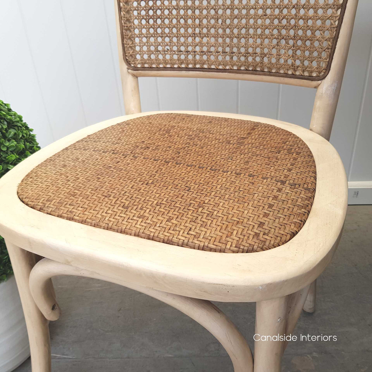 Chic Saxon Chair with rattan back, a durable and easy-to-clean option for busy family dining spaces