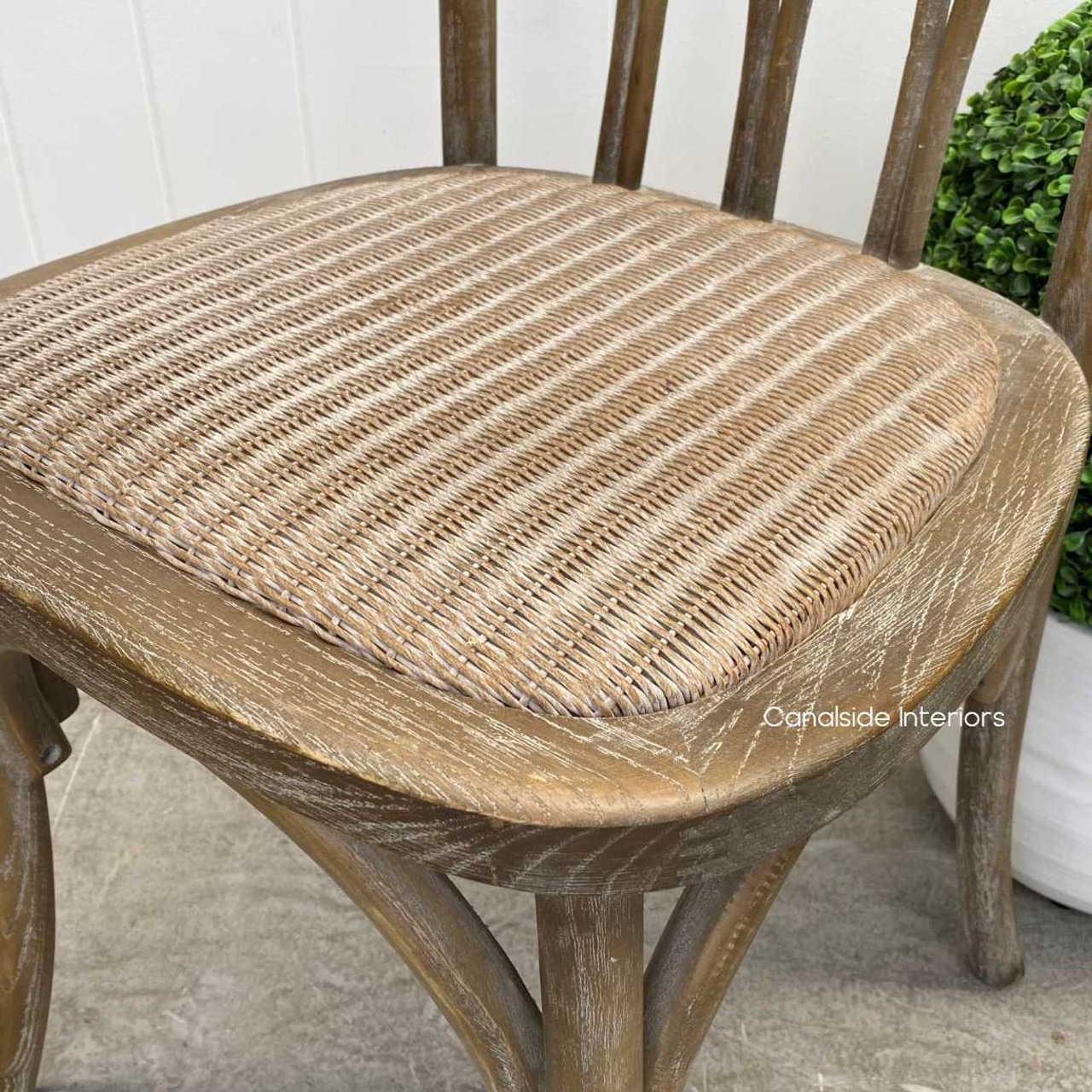 Close-up on the rattan seat of the Botanica Chair, highlighting the comfort and elegance of the slight padding and woven texture.