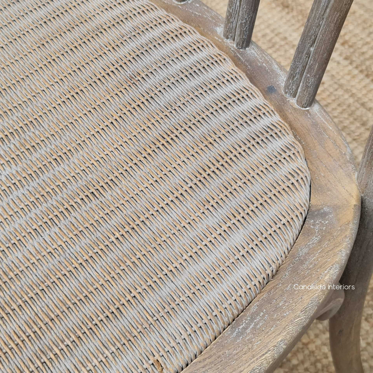Close-up on the rattan seat of the Botanica Chair, highlighting the comfort and elegance of the slight padding and woven texture.