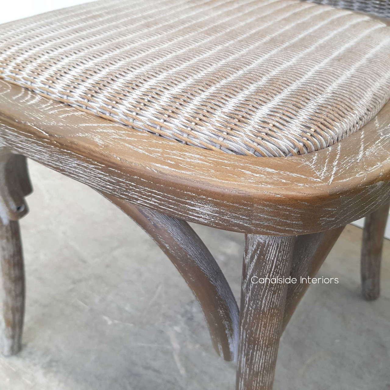 Detail shot of the chair's leg, emphasizing the distressed finish and quality oak material.