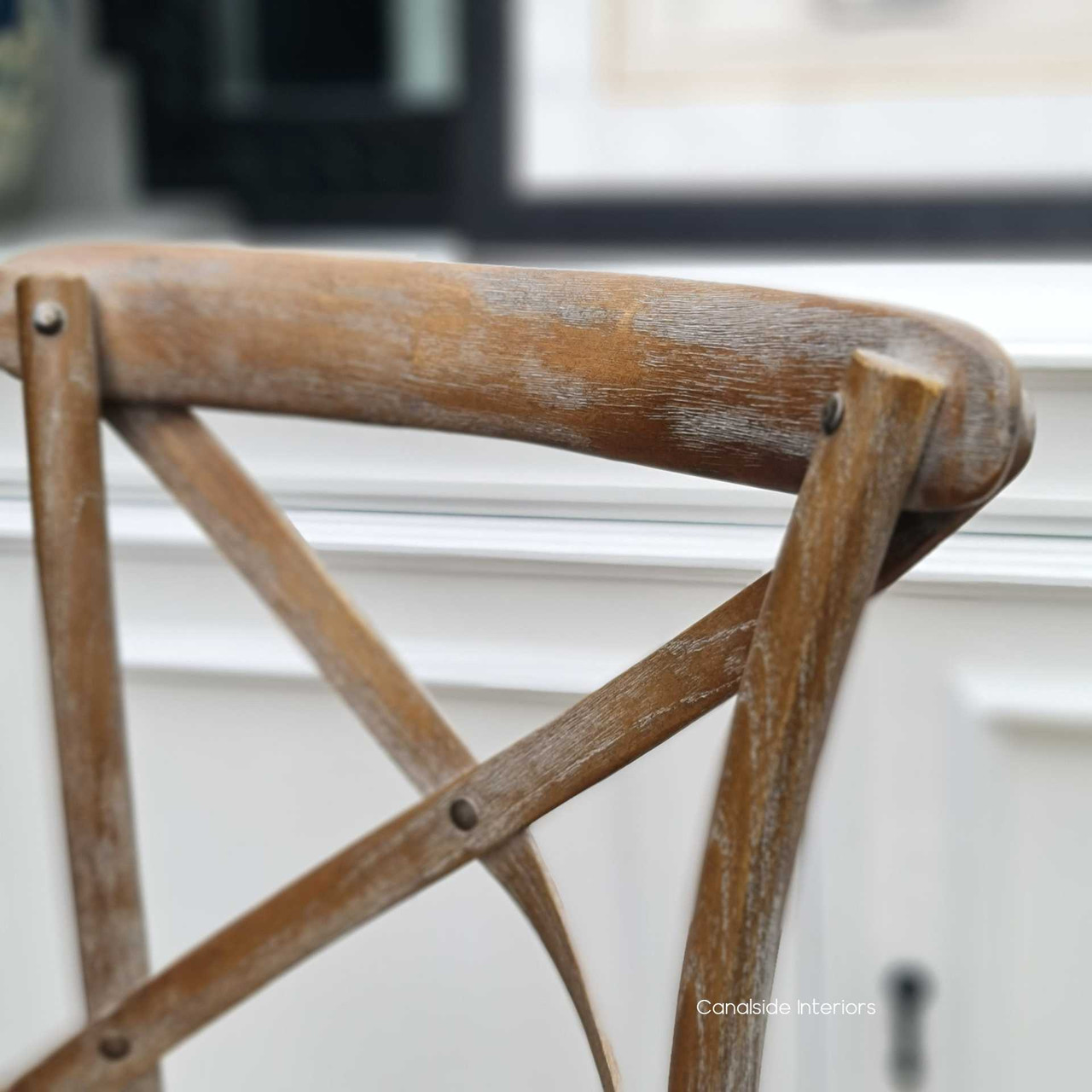 Spotlighting the classic 'X' back design, this image showcases the timeless appeal of the stool, making it an ideal choice for coastal dining settings