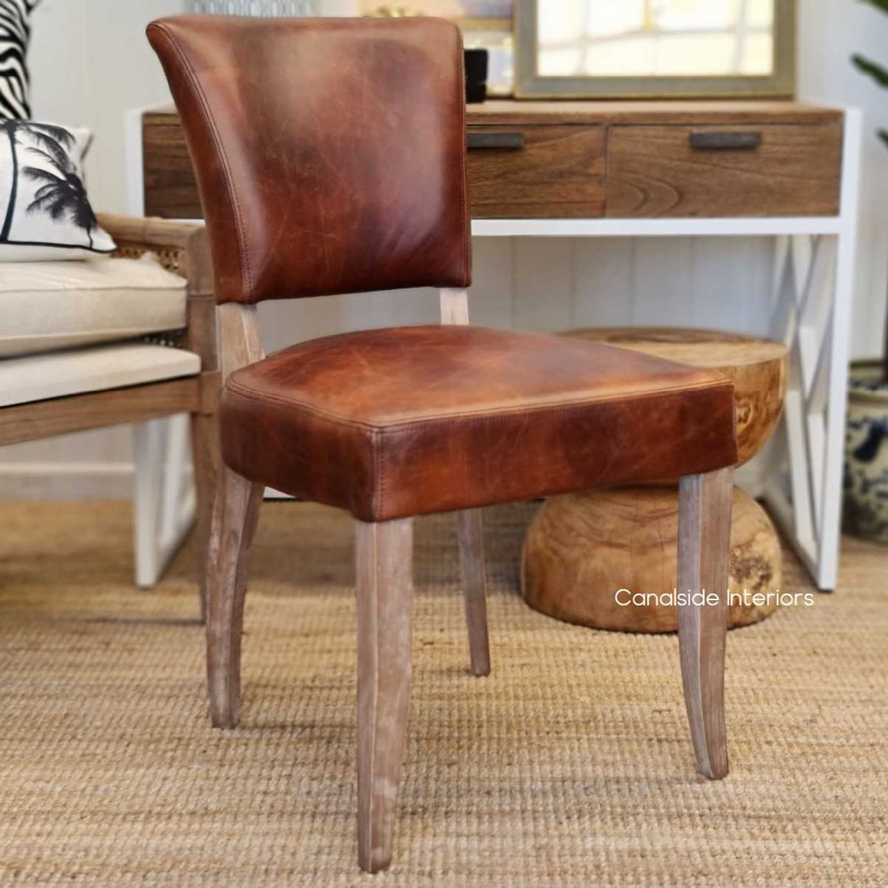 Cuba Aged Leather Dining Chair with waxed finish and weathered oak legs, a testament to timeless quality for dining rooms - Canalside Interiors