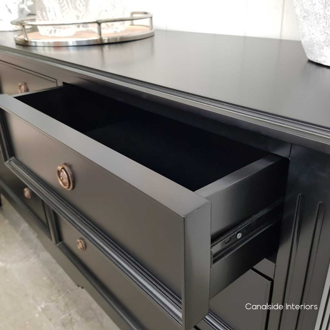 Detail of the smooth metal runners on the drawers, ensuring functionality meets style in this elegant storage piece.