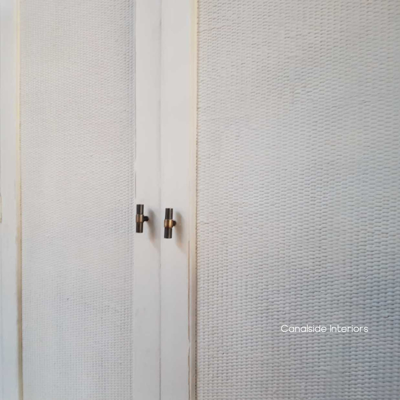 Close-up of the wardrobe's stone rattan work, highlighting the exceptional craftsmanship and texture.