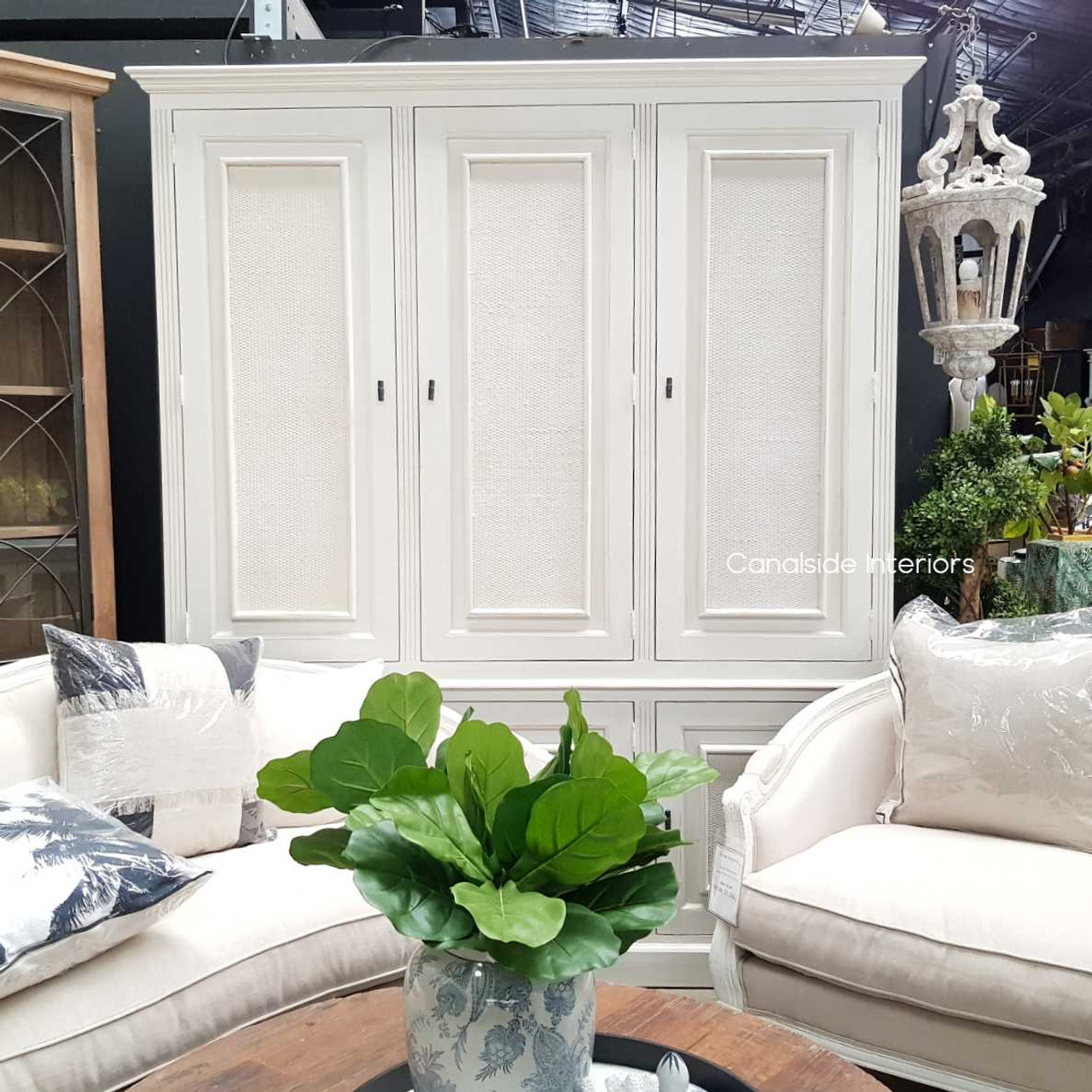 The Brielle Rattan Cupboard styled in a coastal-themed decor, illustrating its seamless integration into elegant interior designs.