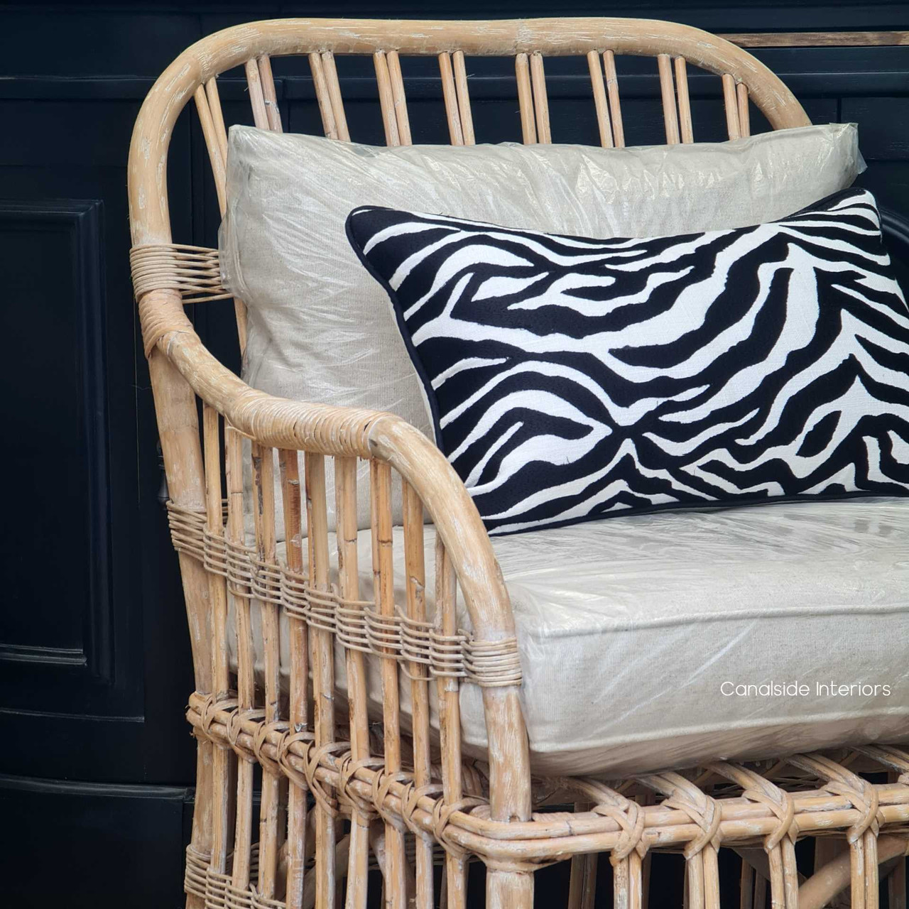 View of the Panama Cane Armchair in a lounge room setting, paired with coastal accessories to enhance its island living vibe.