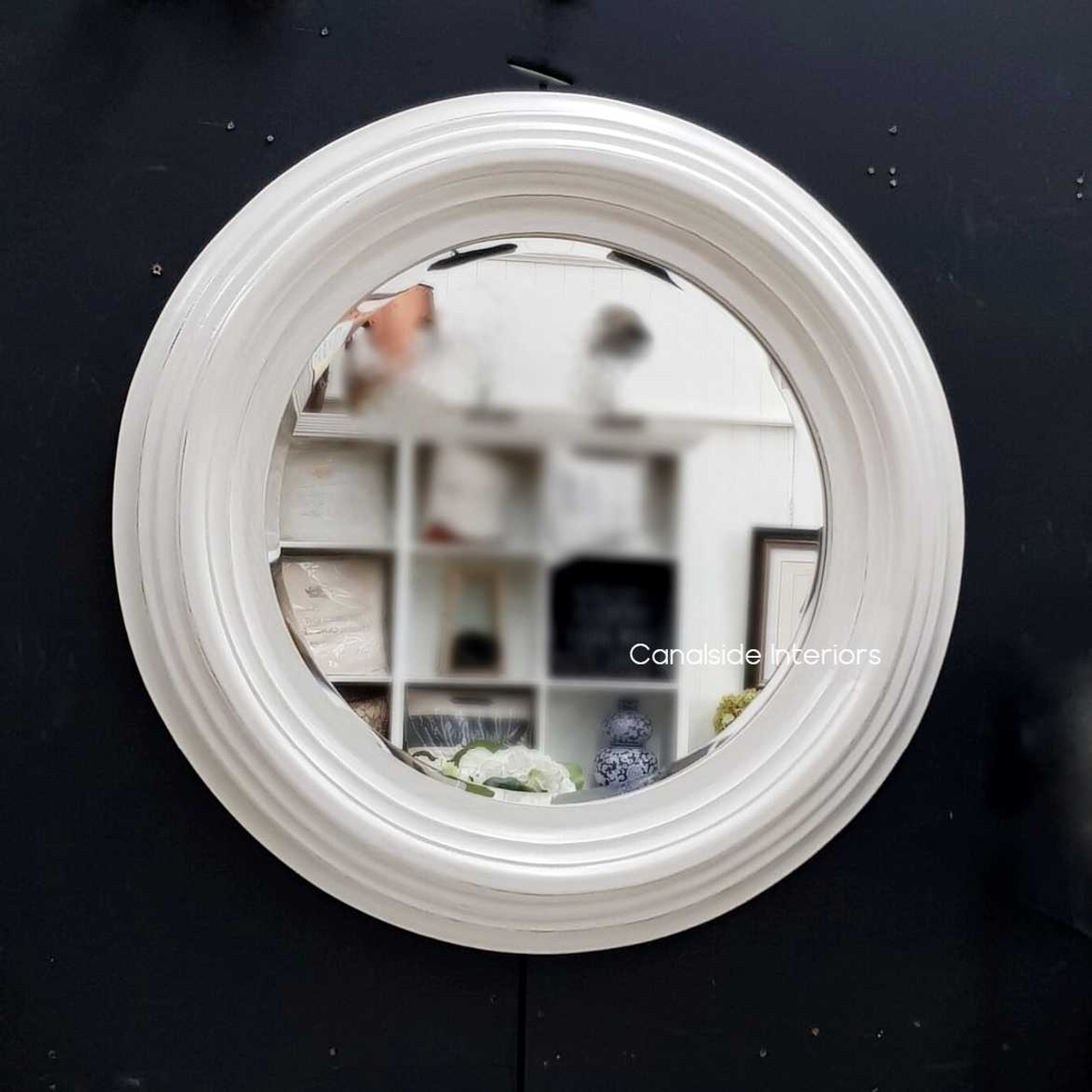 The Aspen mirror under natural lighting, accentuating the warm tones of the distressed white finish and enhancing the ambiance.