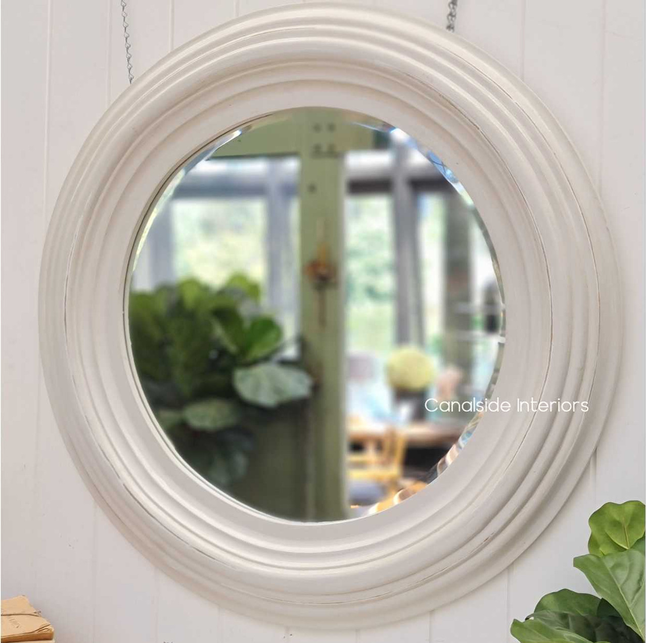 The Aspen mirror under natural lighting, accentuating the warm tones of the distressed white finish and enhancing the ambiance.