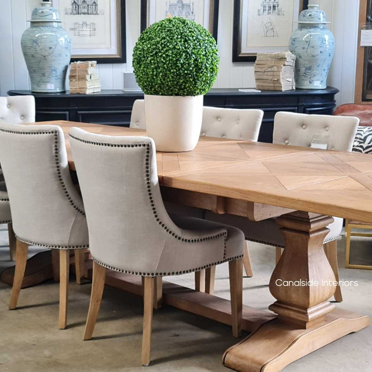Front view of the Hampton Bay Parquetry Double Extension Dining Table closed position, showcasing its elegant parquetry top and solid fruitwood pedestal base.