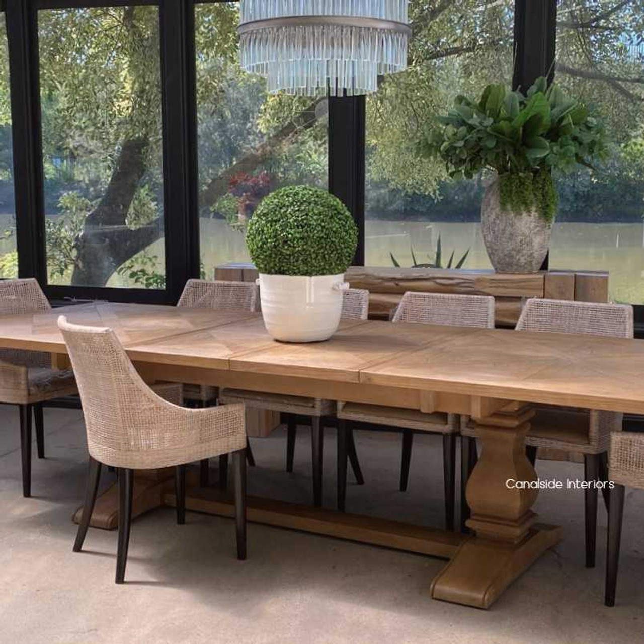 Table set against a backdrop of a large window, where natural light accentuates the beauty of the White Cedar wood and parquetry detail.