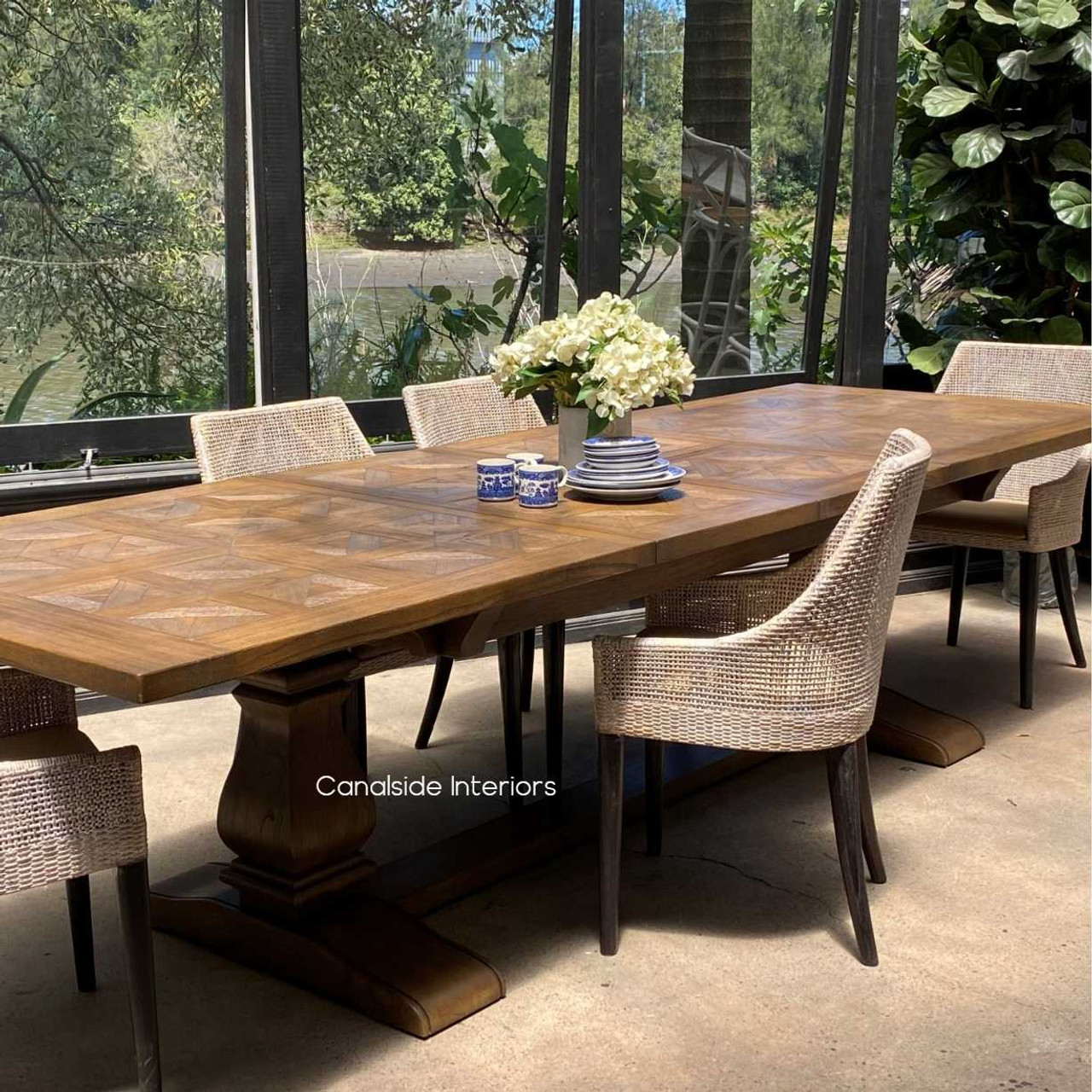 Under ambient lighting, the parquetry top’s colors come to life, adding warmth and depth to the dining experience.