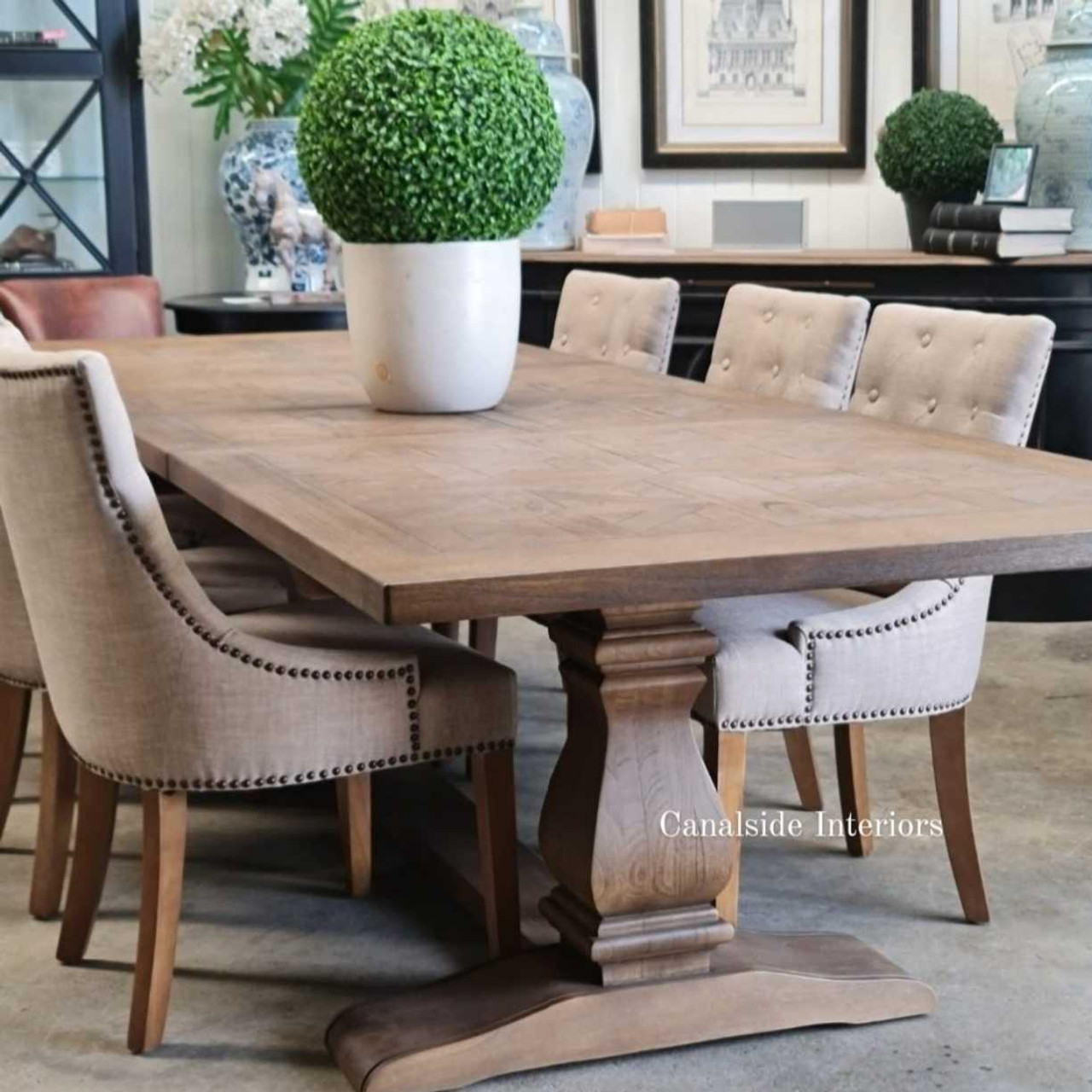Side perspective of the table closed, focusing on the trestle pedestal base and its sophisticated hand-carved details.