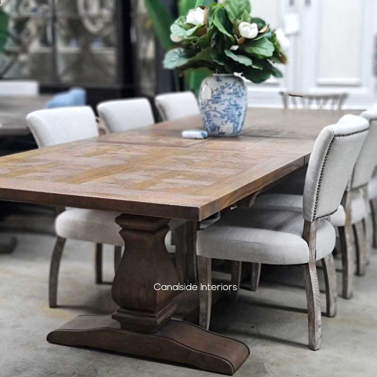 The dining table set against a contemporary background, proving its adaptability to modern and traditional settings alike.