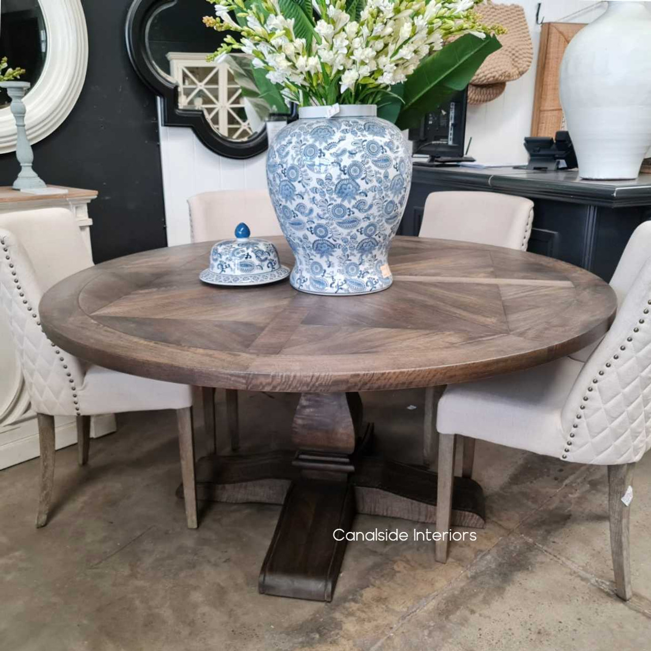 Close-up of the table's hardwood timber finish under natural lighting, accentuating the warm tones and artisanal charm of the hand-crafted parquetry.