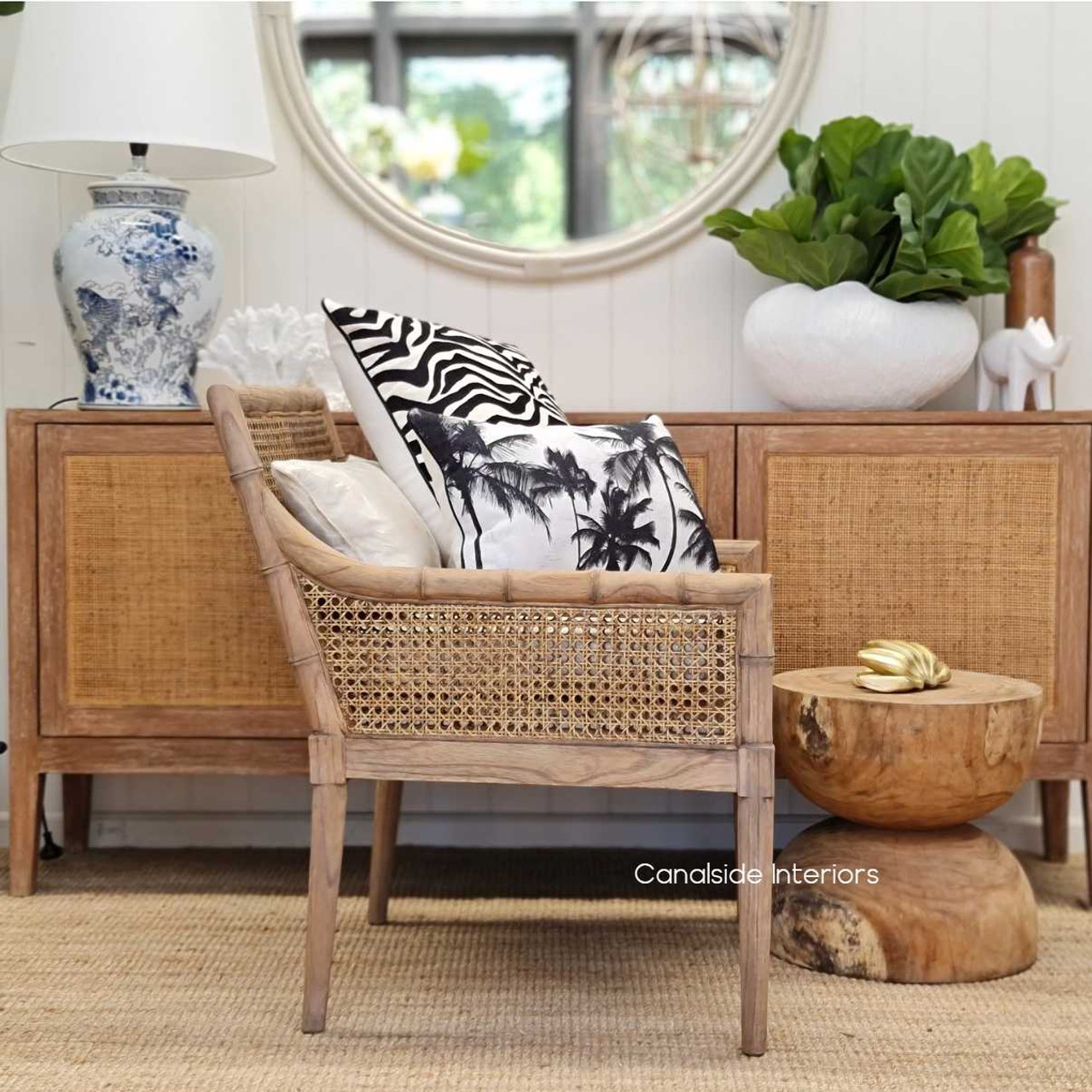 Side profile of the Palmer Plantation Armchair against a library backdrop, merging natural elements with sophisticated design.