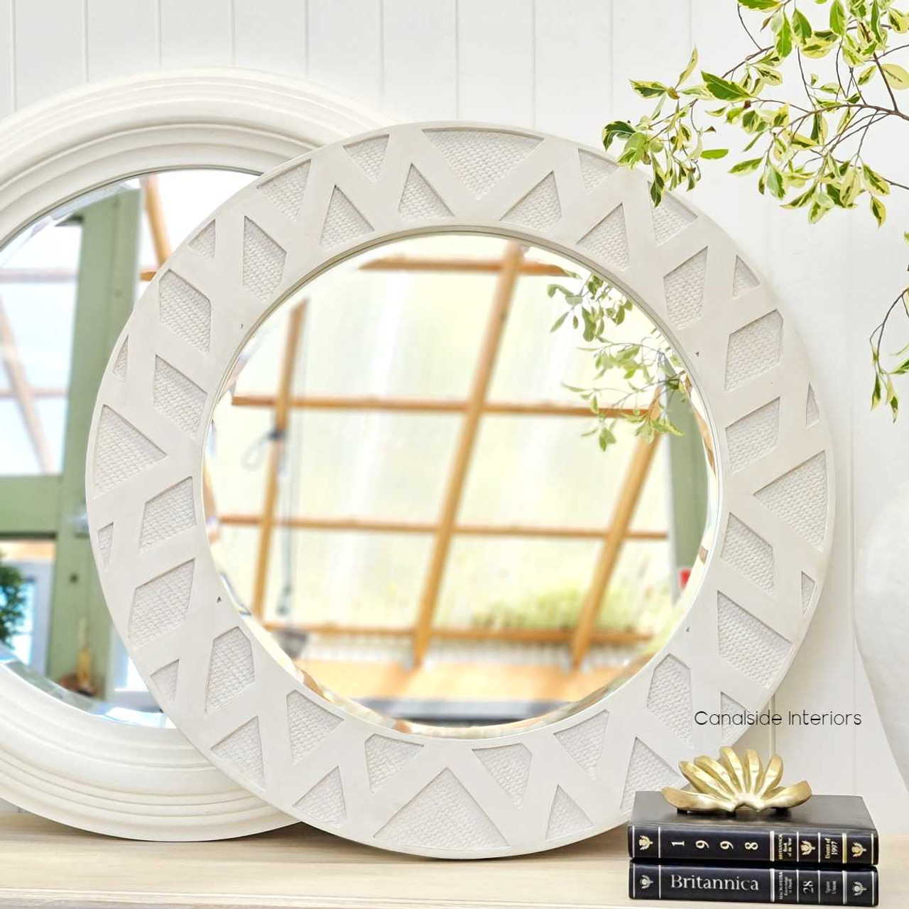 The Botanica mirror set in a chic bedroom, illustrating its stylish presence and functionality as a decorative accent.