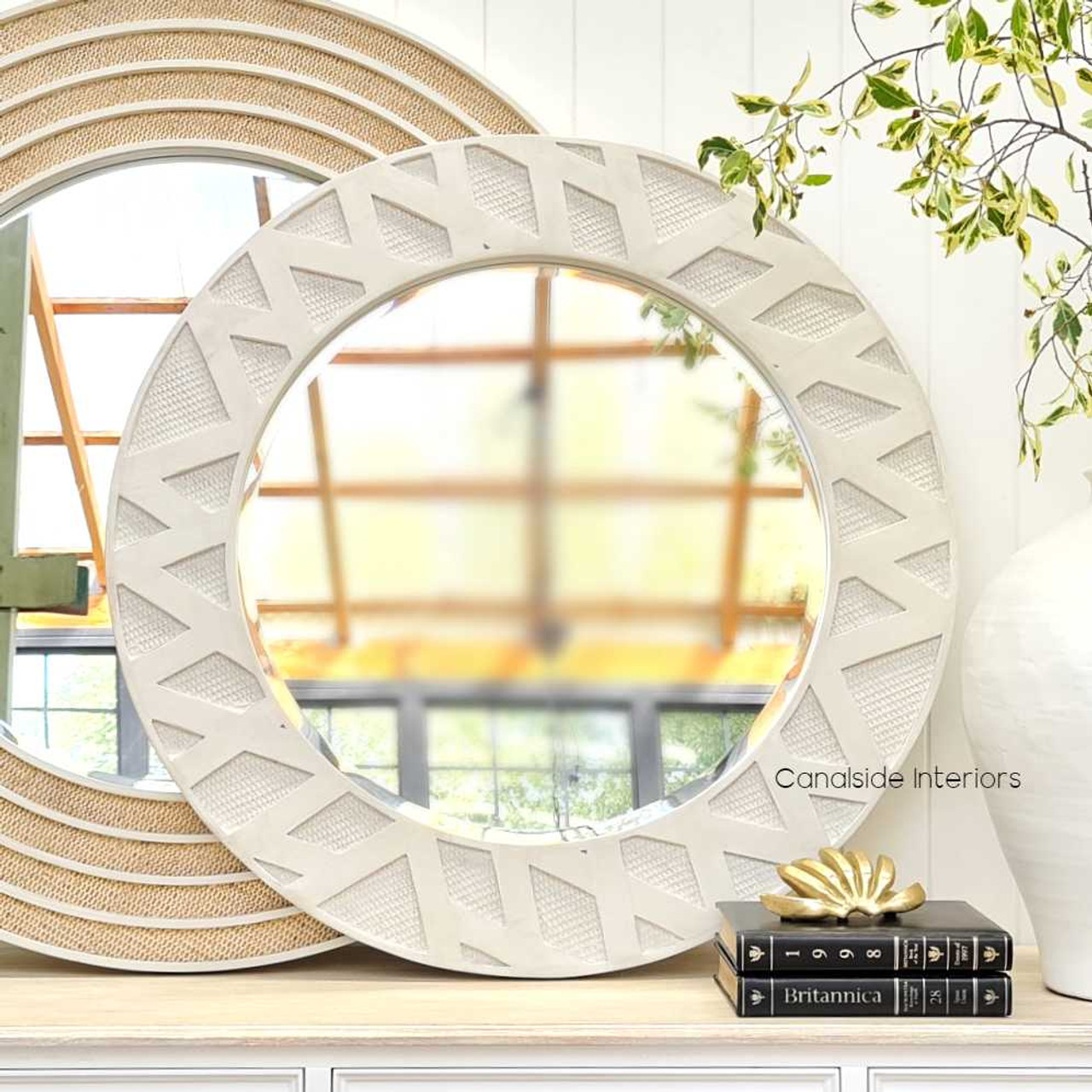The Botanica Rattan Mirror in a cozy living room setting, serving as an elegant and inviting centerpiece.