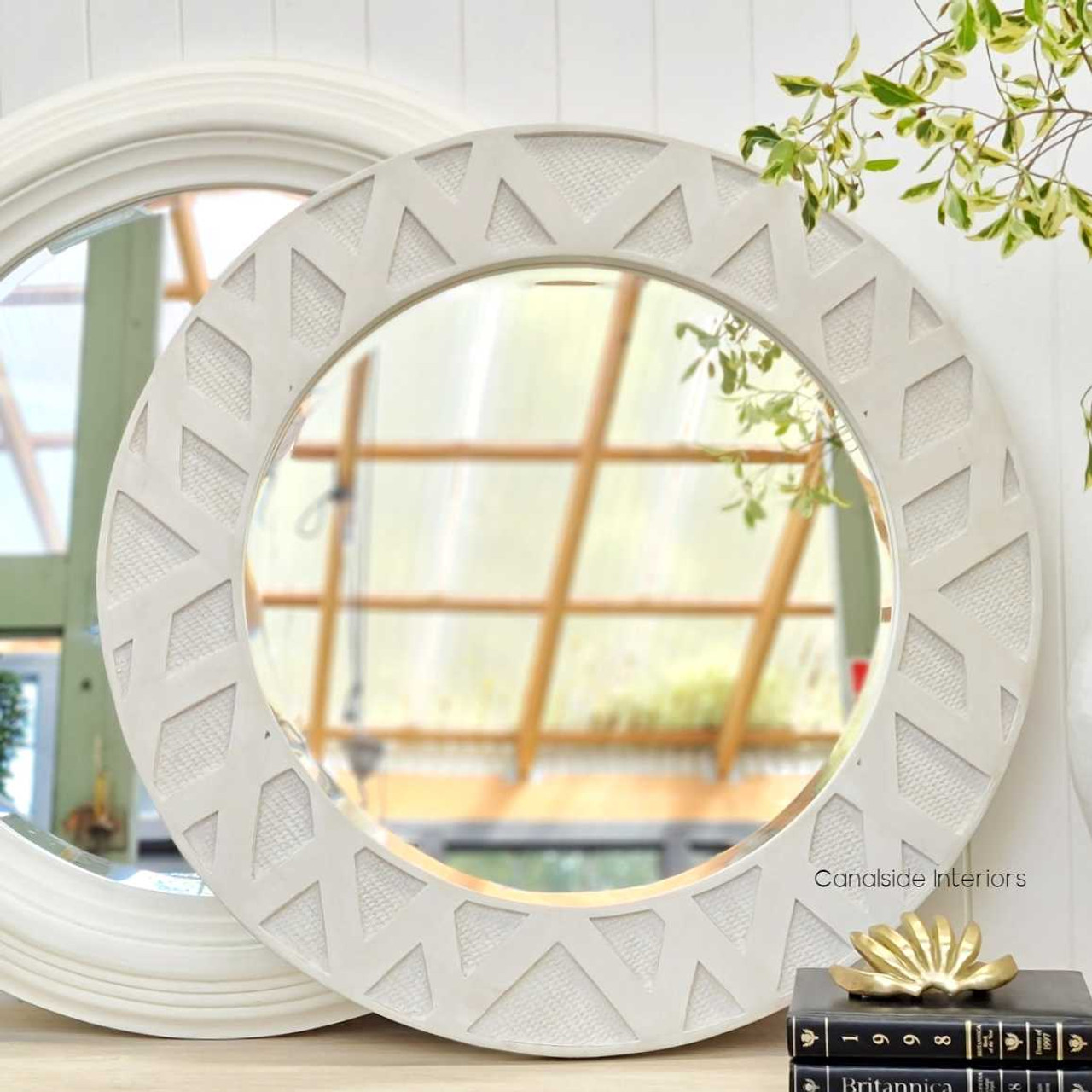 Front view of the Botanica Rattan Round Mirror at Canalside Interiors, showcasing its distinctive distressed stone frame and rattan detailing.