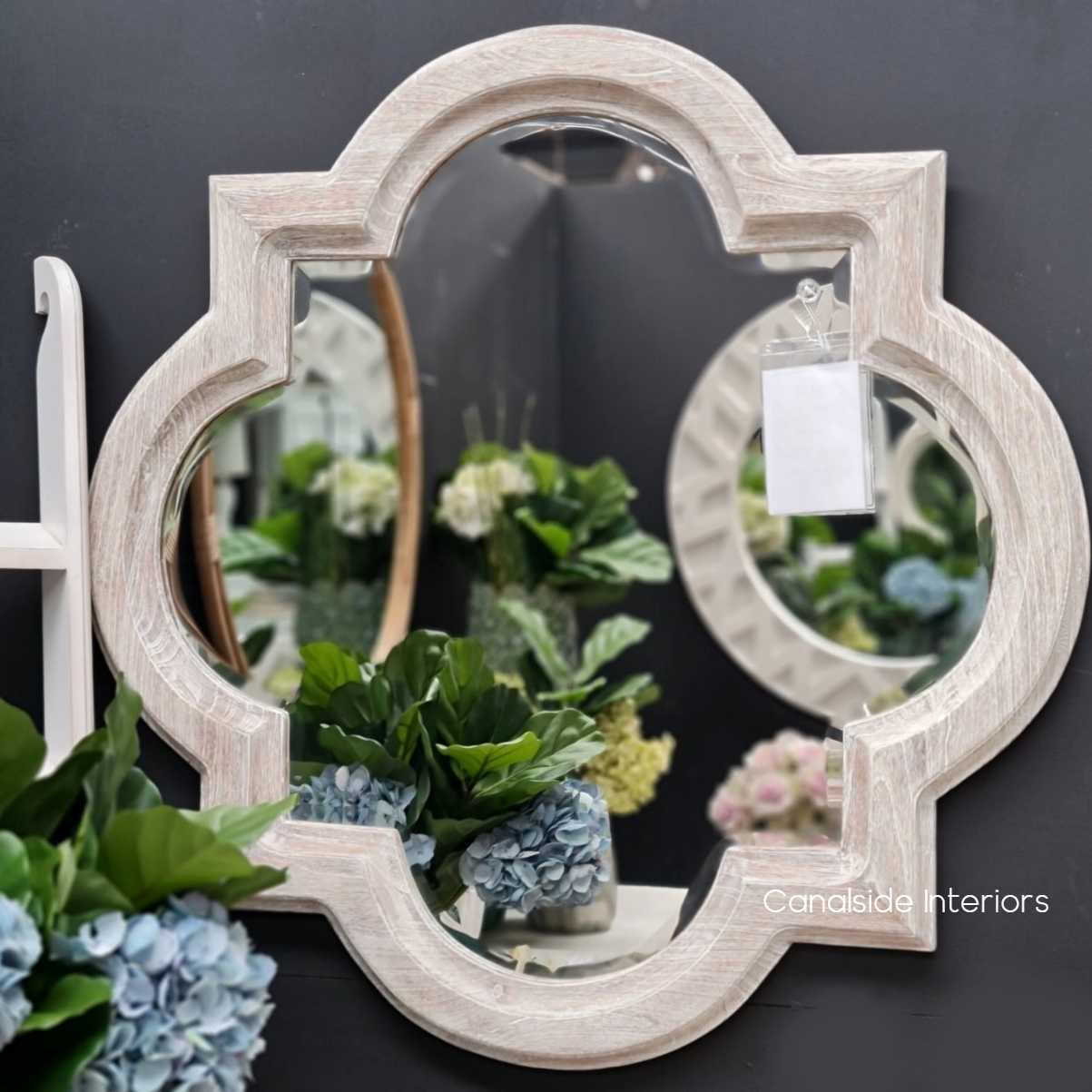 The Cadence Mirror in weathered oak, showcasing its unique shape and natural finish for a classic appeal.