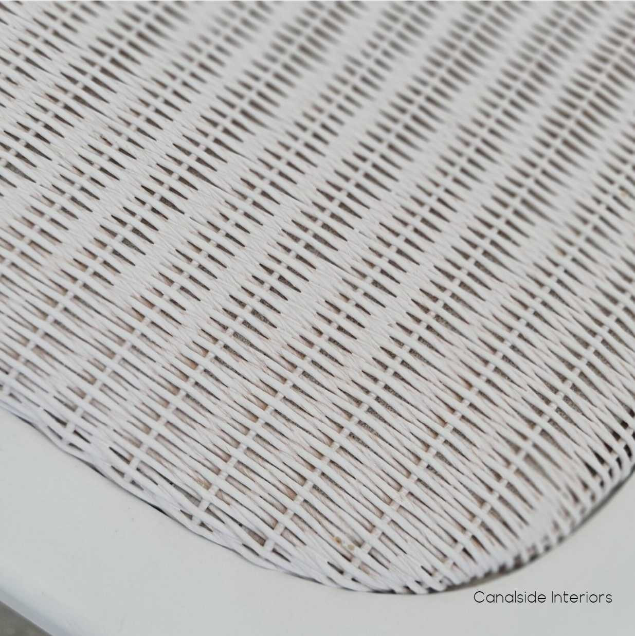 Close-up on the rattan seat of the Botanica Chair, highlighting the comfort and elegance of the slight padding and woven texture.