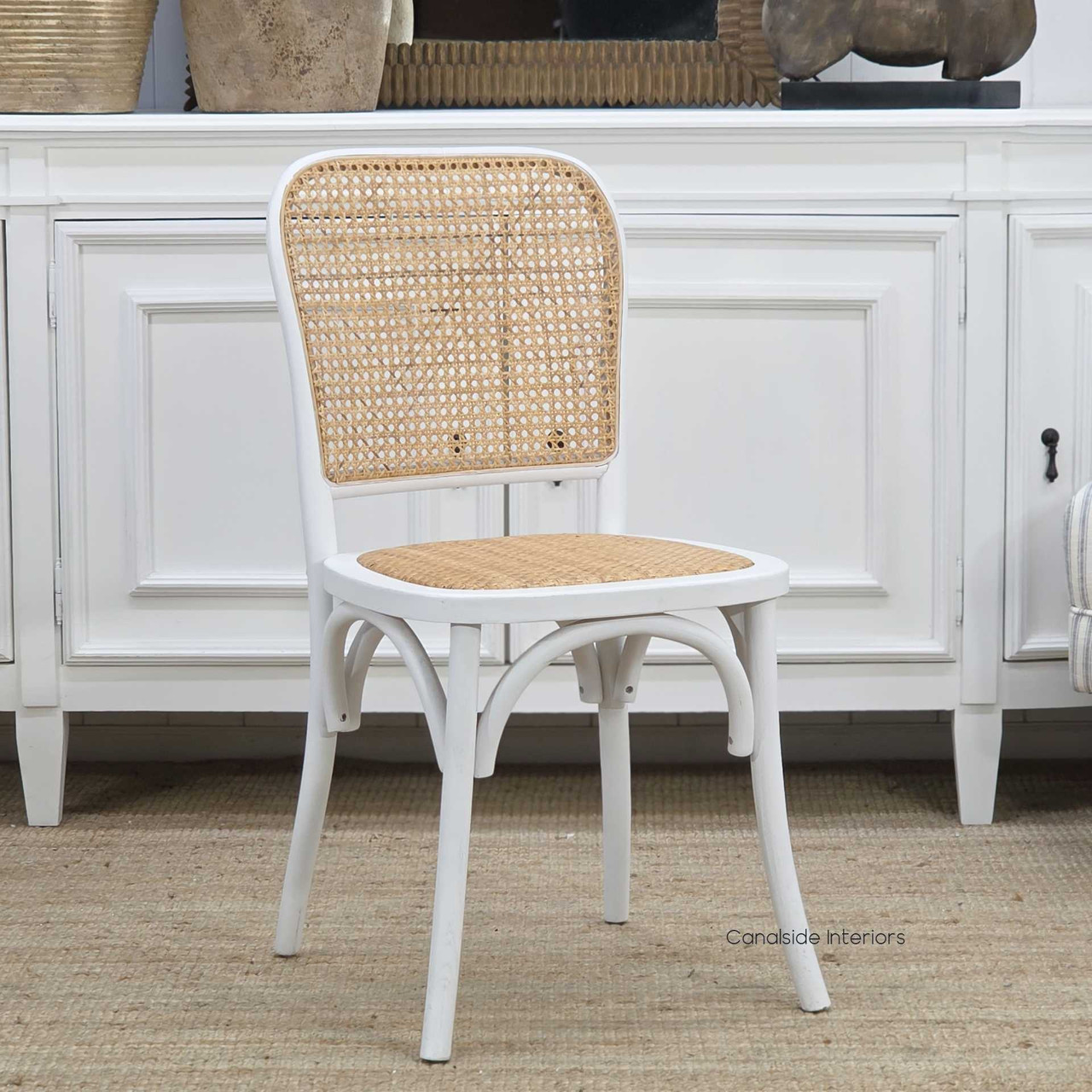 Angled shot of the white Saxon chair highlighting the curved frame and woven rattan backrest