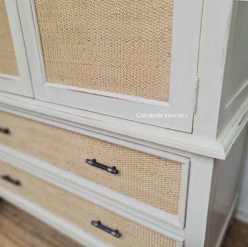 Close-up of the chic metal handles against the natural rattan, adding a touch of luxury to the wardrobe's functional design.