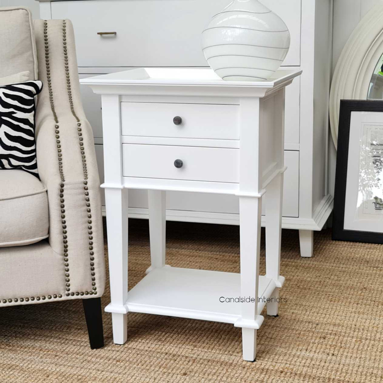 Versatile display in a lounge setting as a chic side table, complemented by decorative items and reading materials.