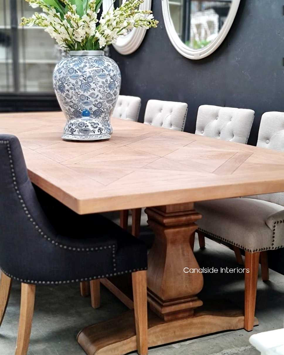 The table in a beach house setting, paired with rattan chairs, blending the lines between indoor luxury and casual, coastal living.
