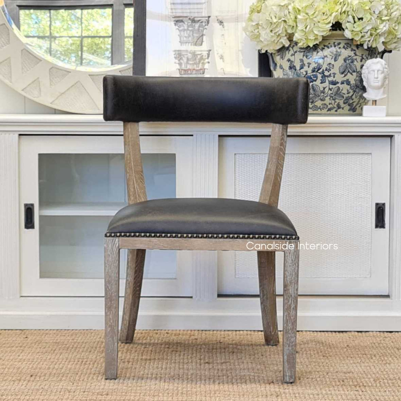 Blending classical detailing with contemporary flair, the Sainz Dining Chair enhances the ambiance of a chic lounge room