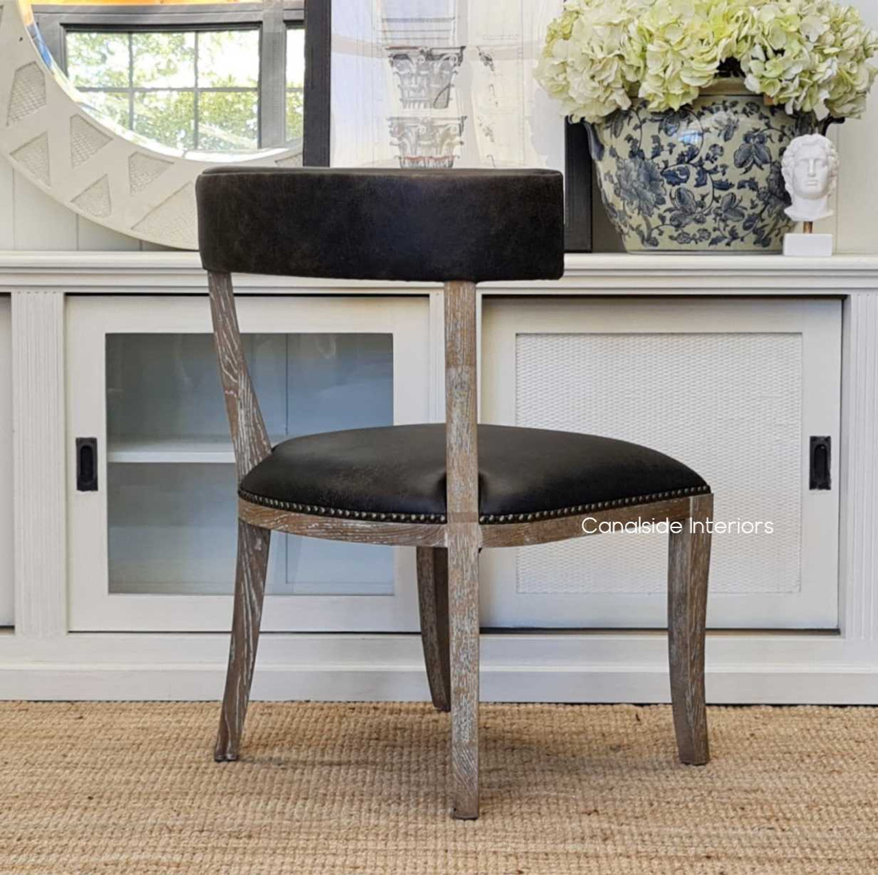 Embrace a blend of American sensibility and European design with the Sainz Aged Leather Dining Chair in your contemporary home - Canalside Interiors.